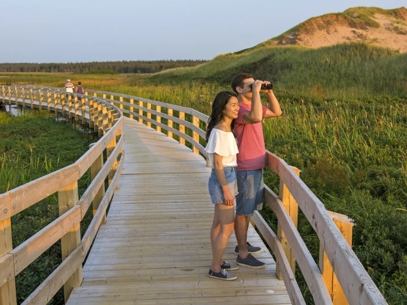 Image of couple on boardwalk at PEI National Park, with link to PEI tourism site. 