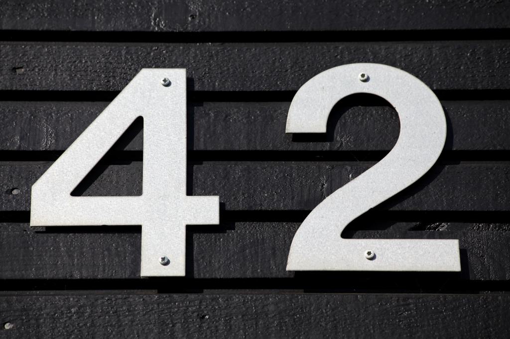 Image of white house numbers on black siding, from Unsplash. 